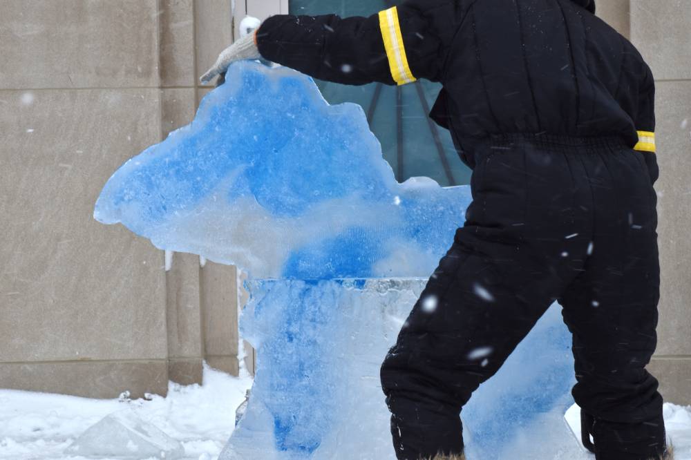 person standing in front of michigan ice sculpture